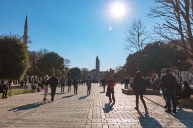 Arka planda Sultanahmet Meydanı 'ndaki turistler ve Theodosius' lu Obelisk. İstanbul Türkiye - 2.20.2024