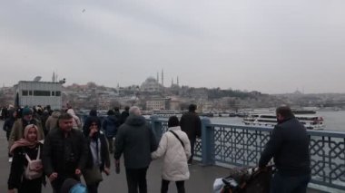 Galata Köprüsü 'nde yürüyen insanlar. Arka planda Süleyman Camii. İstanbul Türkiye - 3.4.2023