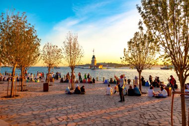 İstanbul arkaplan resmi. İnsanlar gün batımında şehri ve Kiz Kulesi 'ni geziyor. İstanbul Türkiye - 6.8.2024