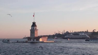 Kiz Kulesi namı diğer Bakireler Kulesi ve arka planda bir yolcu gemisi. İstanbul konsept videosunu ziyaret edin. İstanbul Türkiye - 6.8.2024