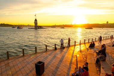 İstanbul 'un arka plan fotoğrafını ziyaret et. Maiden 's Tower ya da Kiz Kulesi günbatımında insanlarla. İstanbul Türkiye - 6.8.2024