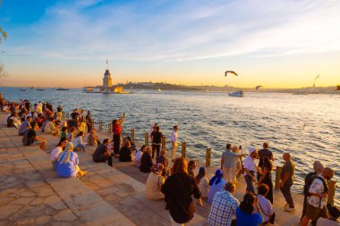 İstanbul manzaralı. Maiden 's Tower ya da Kiz Kulesi gün batımında etrafı gezen insanlarla. İstanbul Türkiye - 6.8.2024