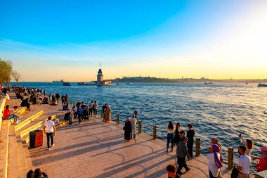İstanbul manzaralı gezici insanlar ve Kiz Kulesi namı diğer Maiden 's Tower gün batımında. İstanbul Türkiye - 5.18.2024