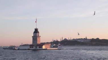 İstanbul manzaralı. Kiz Kulesi namı diğer Bakireler Kulesi, gün batımında İstanbul 'un martıları ve kentsel manzaralı..