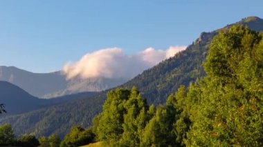 Gün batımında orman üzerinde hareket eden bulutlar dağları kapladı. 4k zaman dilimi videosu. Peyzaj zaman çizelgesi görüntüleri.