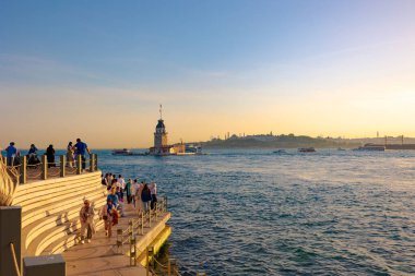 İstanbul 'da gün batımında gezici insanlar ve Kiz Kulesi veya Maiden' s Tower görülüyor. İstanbul Türkiye - 5.18.2024