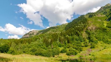 Orman kaplı dağ ve hareket eden bulutlar. Peyzaj zamanaşımı 4k video.