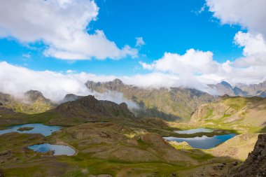 Dağların tepelerinde göller ve yuvarlanan bulutlar. Manzara arkaplan fotoğrafı. Erzurum 'da Ispir yedigoller.