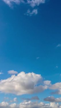 Bulutların hareketi ve mavi gökyüzü dikey hızlandırılmış video. Peyzaj ya da bulutlu zaman dilimi dikey görüntüsü.