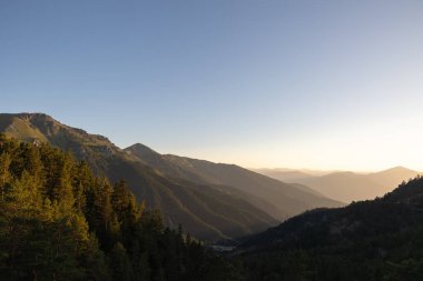 Dağ manzarası gün batımında ormanla kesişir. Doğa fotoğrafı..