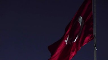 Gece Türk bayrağı sallarken yavaş çekim görüntüleri. Türkiye 'nin ulusal bayram konsept videosu.