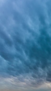 Mammatus veya mammatocumulus bulutları hızlandırılmış videoda hareket eder. Meteoroloji arka planı dikey video.
