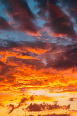 Gün batımında veya gün doğumunda dramatik bulutlar. Gün batımında canlı turuncu bulutlar dikey fotoğraf.