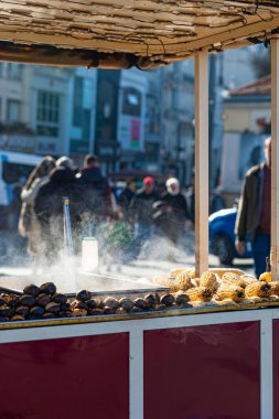 İstanbul 'daki Taksim Meydanı' nda yemek arabasında kavrulmuş kestane ve haşlanmış mısır. Ünlü Türk sokak yemekleri.