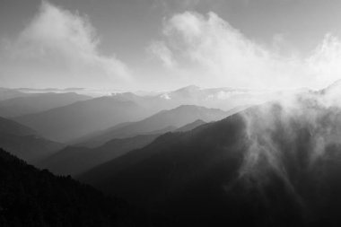Bulanık katmanlı dağlar ve siyah beyaz kareyle kaplı sis. Siyah beyaz manzara fotoğrafı..