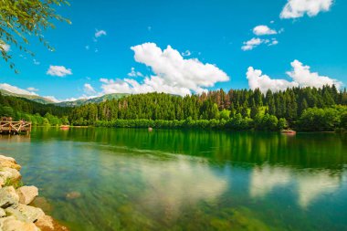Ormandaki parçalı bulutlu göl manzarası. Türkiye 'nin Savsat ilçesindeki Karagol Gölü.
