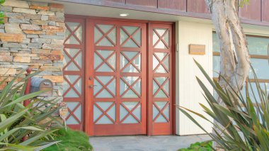 La Jolla, California 'daki Panorama Large' ın cam panelleri ve yan kapıları. Beton girişin her iki tarafında da çimen ve bitkiler var. Sağ tarafında da posta kutusu var..