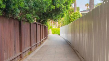 La Jolla, California 'daki çitlerin arasında Panorama Beton Asfalt. Tahta çitin solunda beyaz tahta bir çit var. Sağında ağaçlar var..
