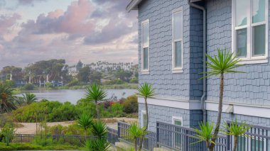 Günbatımında Panorama Puffy Bulutları La Jolla, Kaliforniya 'da bir yerleşim bölgesinde taş döşeme kaldırımı. Komşu ve rıhtım manzaralı evlerin yakınındaki her iki tarafta bitki ve ağaçlarla dolu kıvrımlı patika..