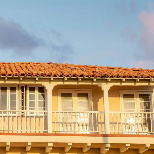 stock image Square Puffy clouds at sunset Terrace of a mediterranean style house with US flag at La Jolla, California. There are four side-hinged double doors at the terrace with windows and white railings.