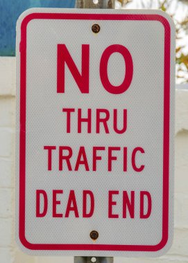 La Jolla, California 'da trafik çıkmaza girmiş. Beyaz beton duvarlara ve büyük mavi vazoya kırmızı harflerle ve kenarlarla yansıtıcı tabela..