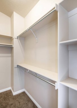 Dikey Dar penceresiz, rafları ve metal çubukları olan bir dolap. Boş bir dolap. Raflarda ve kahverengi halıların döşemesinde inşa edilmiş..