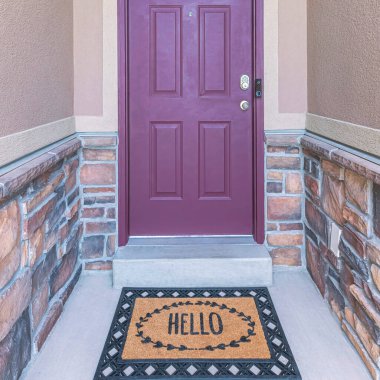 Kare Mor ön kapı kemerli pencere ve dijital anahtar erişimi var. Duvarların ortasındaki bir evin girişinde taş kaplamalı kaplamalar ve kapının yanında güvenlik kamerası var..