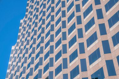 Austin Texas 'taki modern ofis binasının pencereleri mavi gökyüzünü yansıtıyor. Mavi gökyüzü arka planına karşı ticari veya konut birimi cephesi manzaralı şehir silüeti.