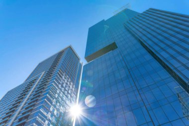 Güneş ve mavi gökyüzüne karşı yükselen modern cam konut binaları. Austin Texas 'ta çağdaş konut mimarisi olan apartmanların dış görünüşü.
