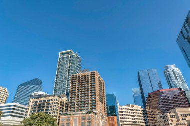 Austin, Teksas... Mavi gökyüzü arka planına karşı alçak açılı bir manzara. Farklı tasarım ve yapılara sahip binalar.