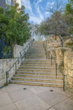 San Antonio, Teksas. San Antonio Nehri yakınlarındaki River Walk 'daki merdiven. Soldaki taş duvarların ortasında parmaklıkları olan merdivenler ve sağdaki ağaçların yanındaki kaya duvarları..