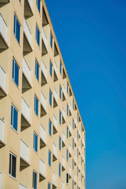 Destin, Florida 'da balkonlu ve pencereli bir bina. Bej duvar dış görünüşü ve mavi gökyüzü arkaplanı olan bir apartmanın yan görüntüsü.