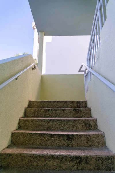 Destin Florid 低角度打开楼梯井 有花岗岩台阶和挂满墙壁的白色金属栏杆的楼梯 可以看到外面的天空和建筑 — 图库照片