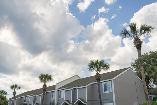 Gökyüzündeki kabarık bulutlara karşı bitişik evlerin alçak açılı görüntüsü... Destin, FL. Gri dış görünüşlü evler.
