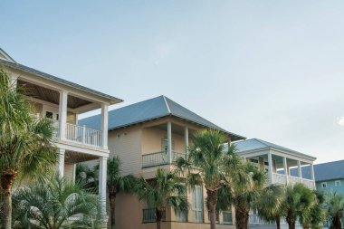 Miami, Florida 'da, cephede palmiye ağaçlarına bakan balkonlu evler. Gökyüzüne karşı ahşap kaplamalı evler..
