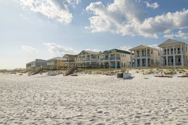 Destin, Florida- Beach houses with footbridges over the sand dunes. Beach with white sand and a view of three-storey houses with balconies.