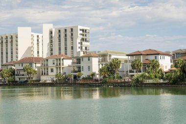 Destin, Florida 'da göl manzaralı üç katlı villalar ve apartmanlar. Önünde tuzlu su, arkasında villalar ve apartman manzarası olan bir göl manzarası..