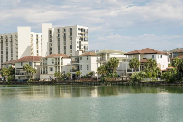 Destin, Florida 'da göl manzaralı üç katlı villalar ve apartmanlar. Önünde tuzlu su, arkasında villalar ve apartman manzarası olan bir göl manzarası..