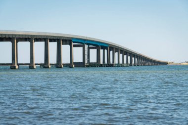 Destin, Florida 'daki su yolu üzerinde Navarre Sahili Geçidi. Açık mavi gökyüzü arkaplanına karşı bir köprü otoyolu görüntüsü.