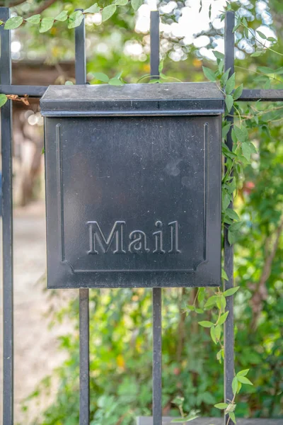 サンアントニオ テキサス州 前面にエンボス加工のメールボックス付きブラックスチール壁に取り付けられたメールボックス 背景の植物の近くの柵の手すりにメールボックス — ストック写真