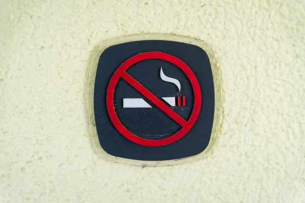 Destin, Florida- No smoking symbol signage on a painted textured wall. Symbol of a no smoking with black background and red no symbol.