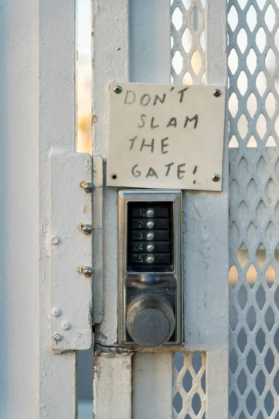 ゲートのデスティン フロリダ ステンレス製のキーコードロックゲートノートをスラムしないでください 白い金属レールと膨張した鋼板を持つゲートのロックの閉鎖 — ストック写真