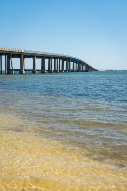 Florida, Destin 'deki su yolu üzerinde Navarre Sahili Geçidi dikey çekim. Koydaki kıyı köprüsünün temiz gökyüzü arkaplanının görüntüsü.