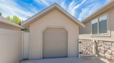 Panorama Fısıldayan Beyaz Bulutlar, kenar girişi ve bölgesel kapısı olan araç kulübesi. Evin solunda taş kaplamalı ve sağında vinil çitli bir kapı var..