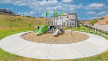 Panorama Beyaz Kabarık Bulutlar... Utah 'ın çitli yerleşim alanının dışındaki oyun alanı. Soldaki beton yola yakın oyun parkı ve tepesinde evler olan çimenli tepe..