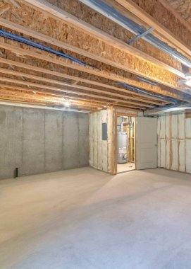 Beton döşemeleri ve ahşap çerçeveleri olan tamamlanmamış dikey bir bodrum katı. Yalıtımlı bir duvar var. Yan tarafında iki kapı açılıyor..