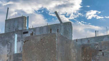 Panorama Beyaz Kabarık Bulutlar beton duvarlı bir evin yeraltı desteği. Ev bodrumu dış görünüşü alçak açılı bulutlu gökyüzüne karşı.