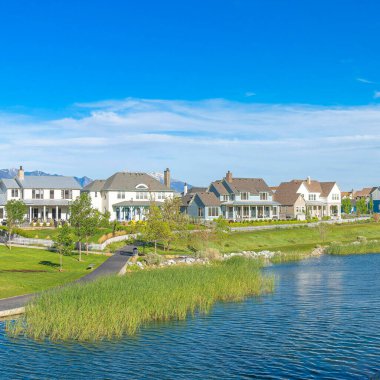 Kare Fısıldayan Beyaz Bulutlar, Utah, Daybreak 'teki huzurlu yerleşim bölgesinin panoramik görüntüsü. Oquirrh Gölü 'nün bir yansıtıcı suyu var. Yaya geçidinin yanındaki yerleşim alanının ortasında, dağ manzaralı..