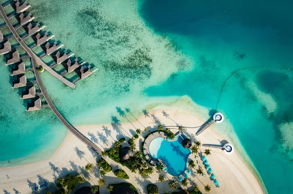 Güzel Maldivler cenneti tropikal plajının havadan çekilmiş fotoğrafı. Muhteşem manzara, mavi turkuaz göl suyu, palmiye ağaçları ve beyaz kumlu plaj. Lüks seyahat tatil beldesi. Güneşli hava manzarası
