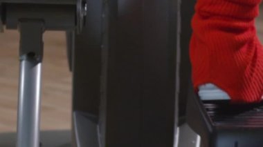 Female legs working out on exercise machines in the gym close-up. High quality FullHD footage
